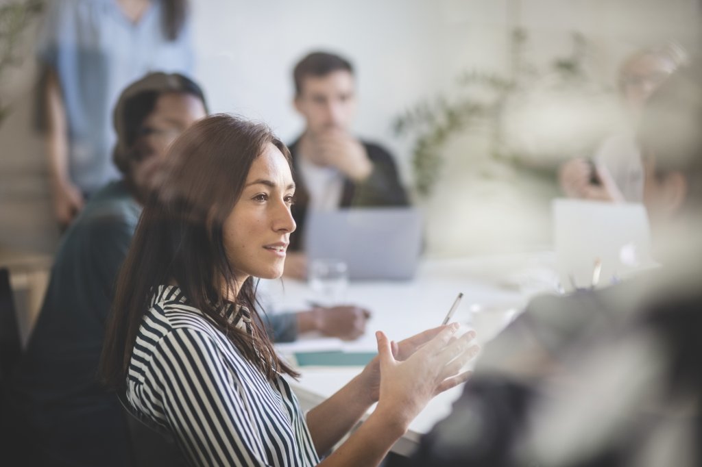 A group of people sitting around a table in a meeting on corporate communications.