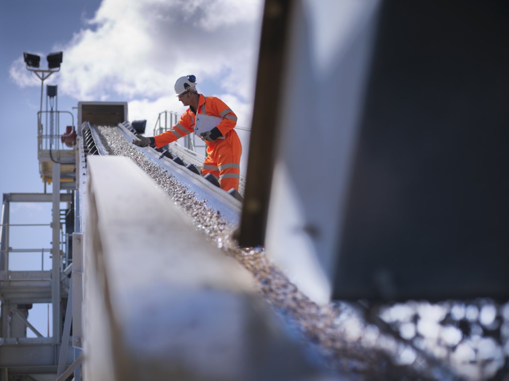 Worker standing by stone screening and crushing machine.